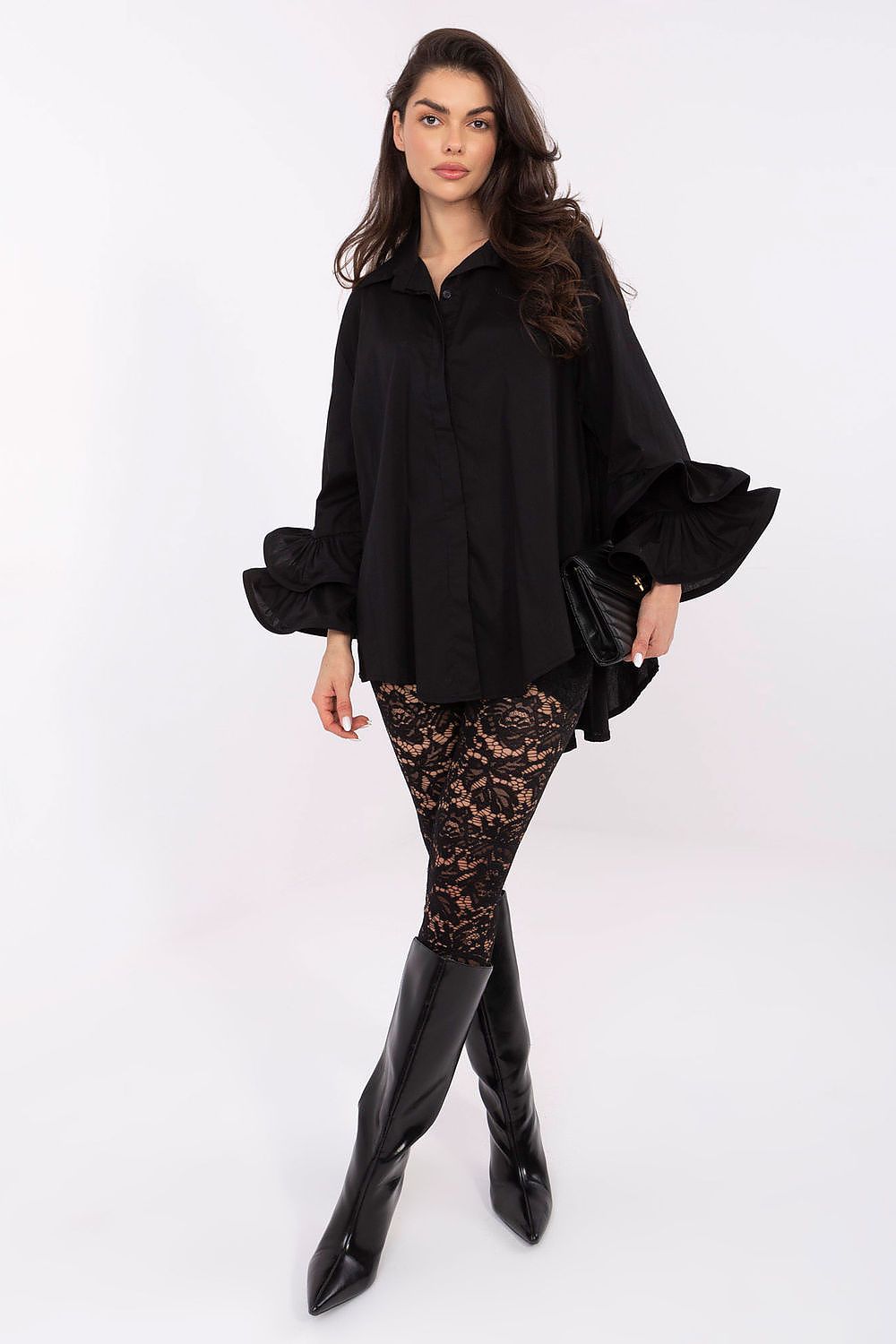 Woman wearing a black outfit with a lace tights and black boots on a white background