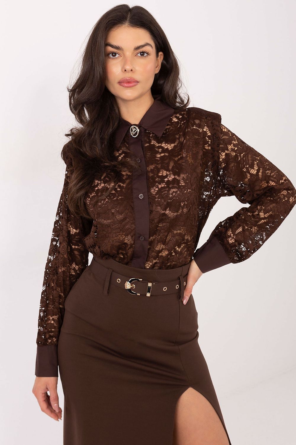 Woman wearing a brown lace blouse and skirt with a belt on a white background