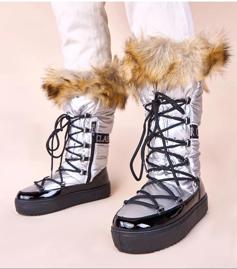 High-top snow boots with fur trim on a beige background