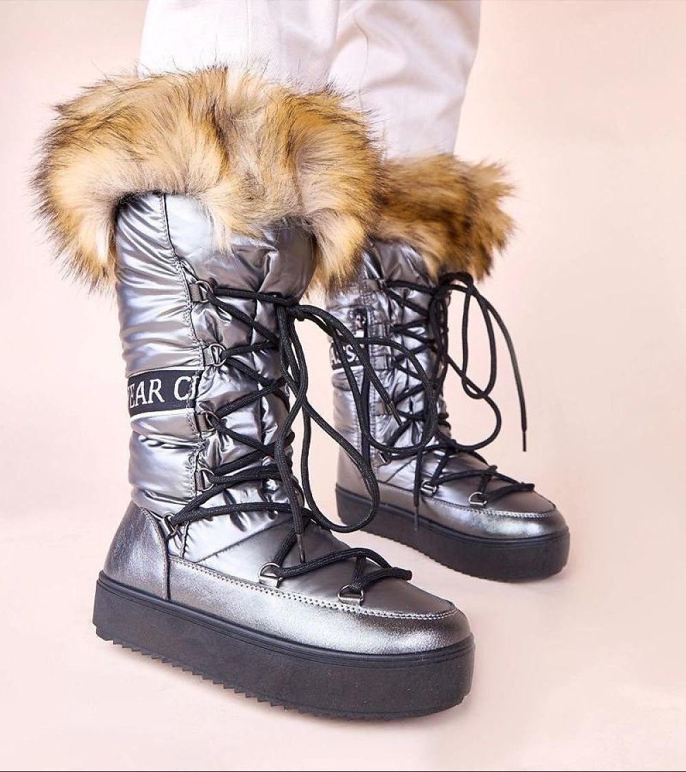 Silver winter boots with fur trim on a light background