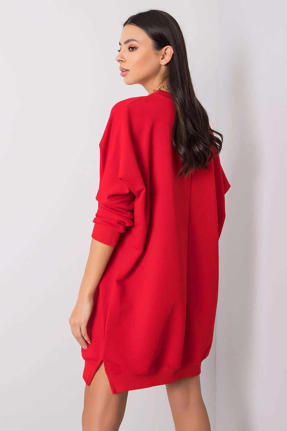 Woman wearing a red dress against a plain background
