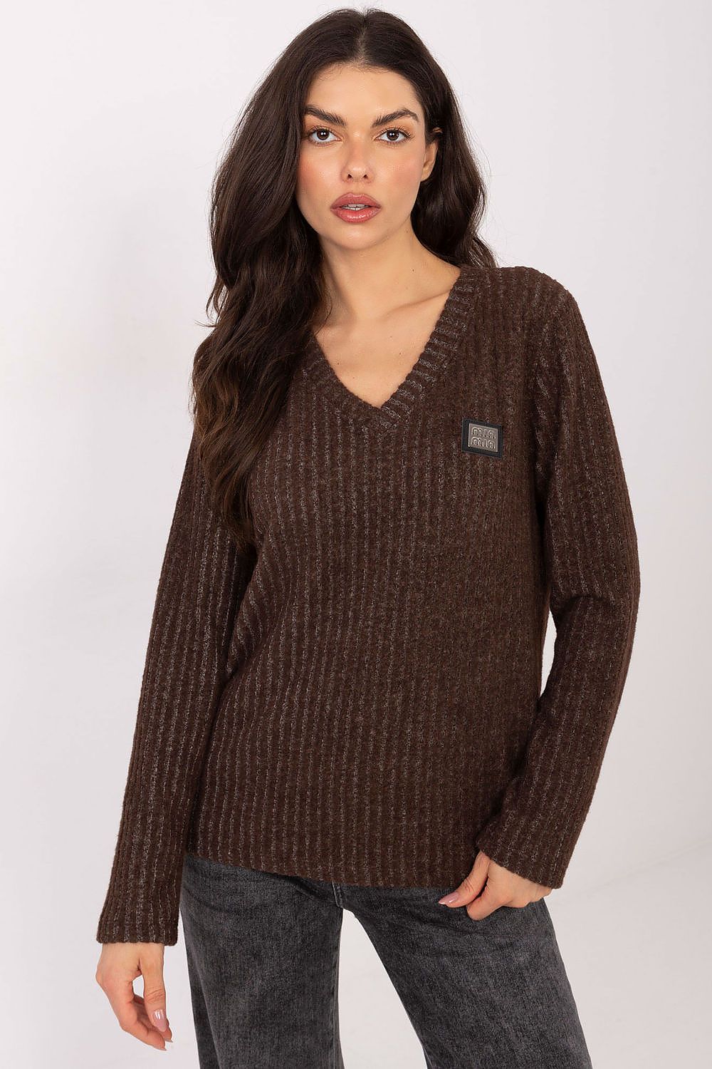 Woman wearing a brown sweater with a small logo on a white background