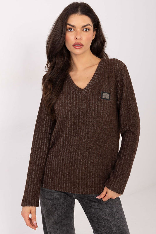 Woman wearing a brown sweater with a small logo on a white background