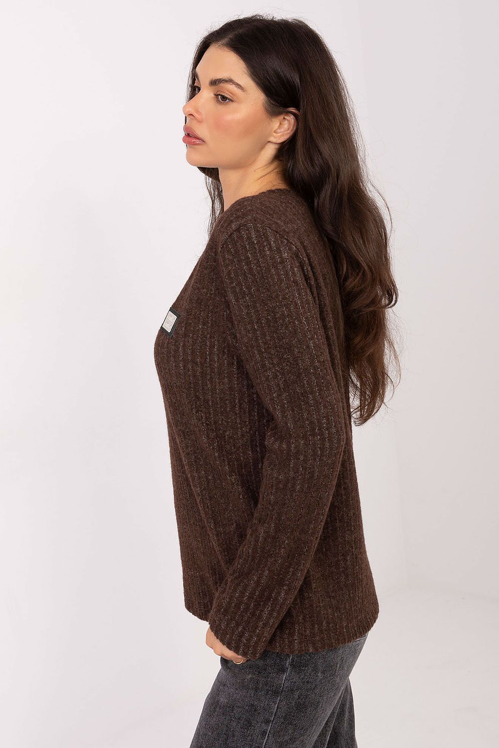 Woman wearing a brown sweater against a white background