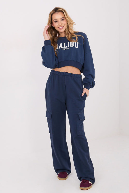 Woman wearing a navy blue 'Malibu' sweatshirt and cargo pants on a white background