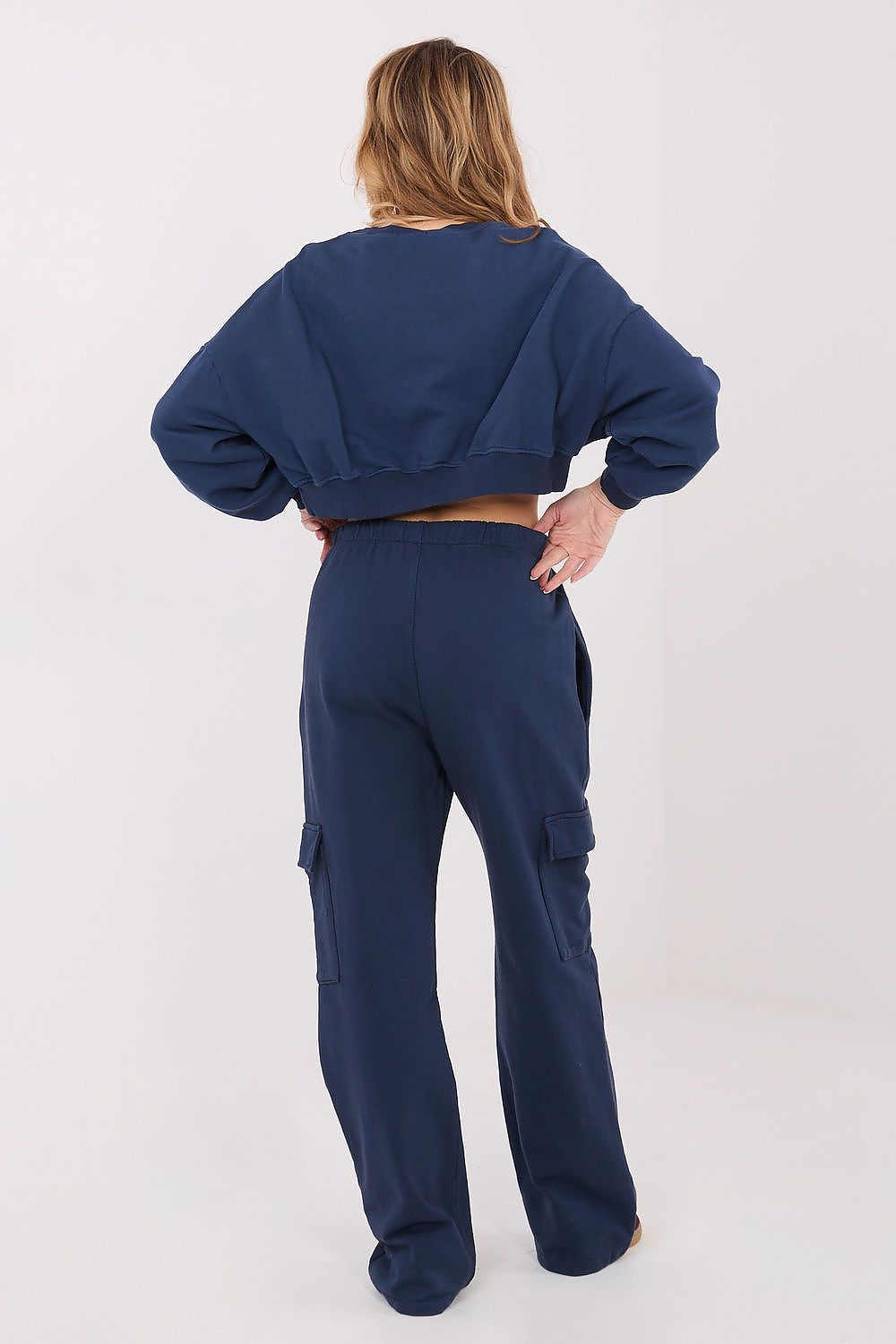 Person wearing a navy blue tracksuit on a white background