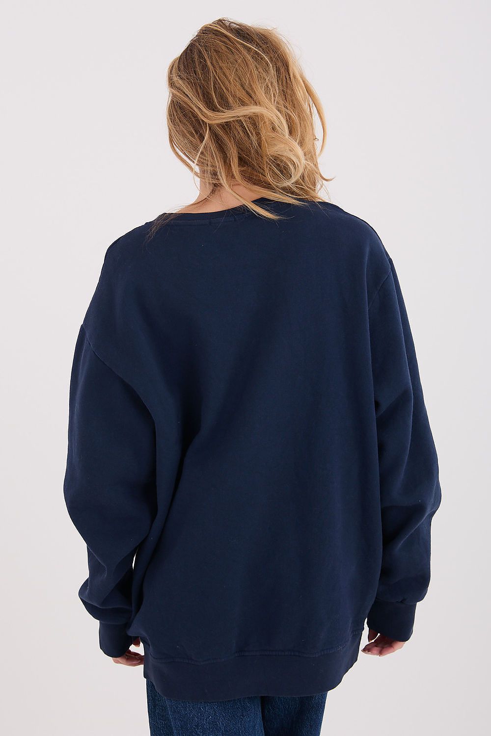 Person wearing a navy blue sweatshirt on a white background