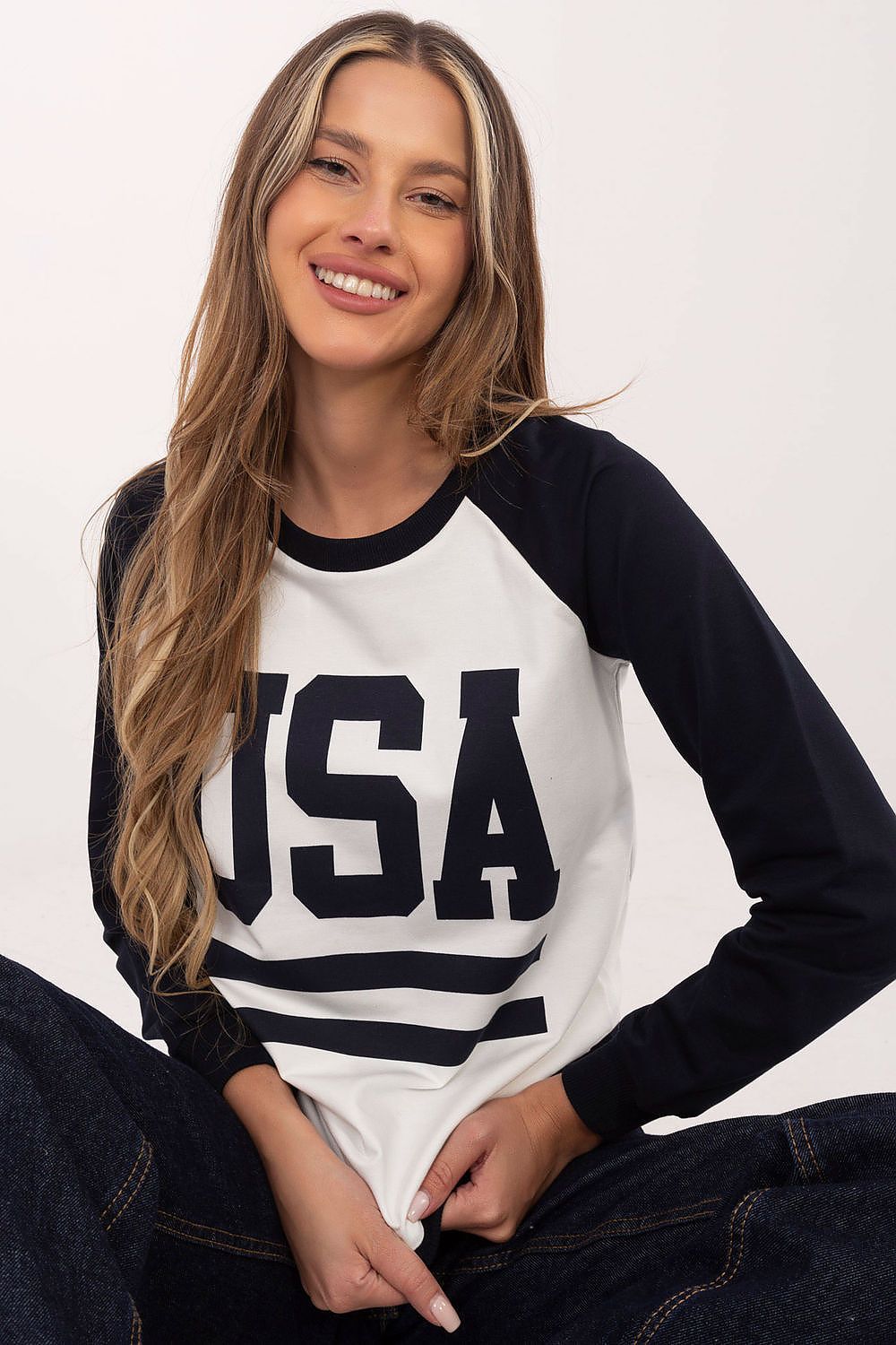 Woman wearing a black and white 'USA' long-sleeve shirt against a plain background