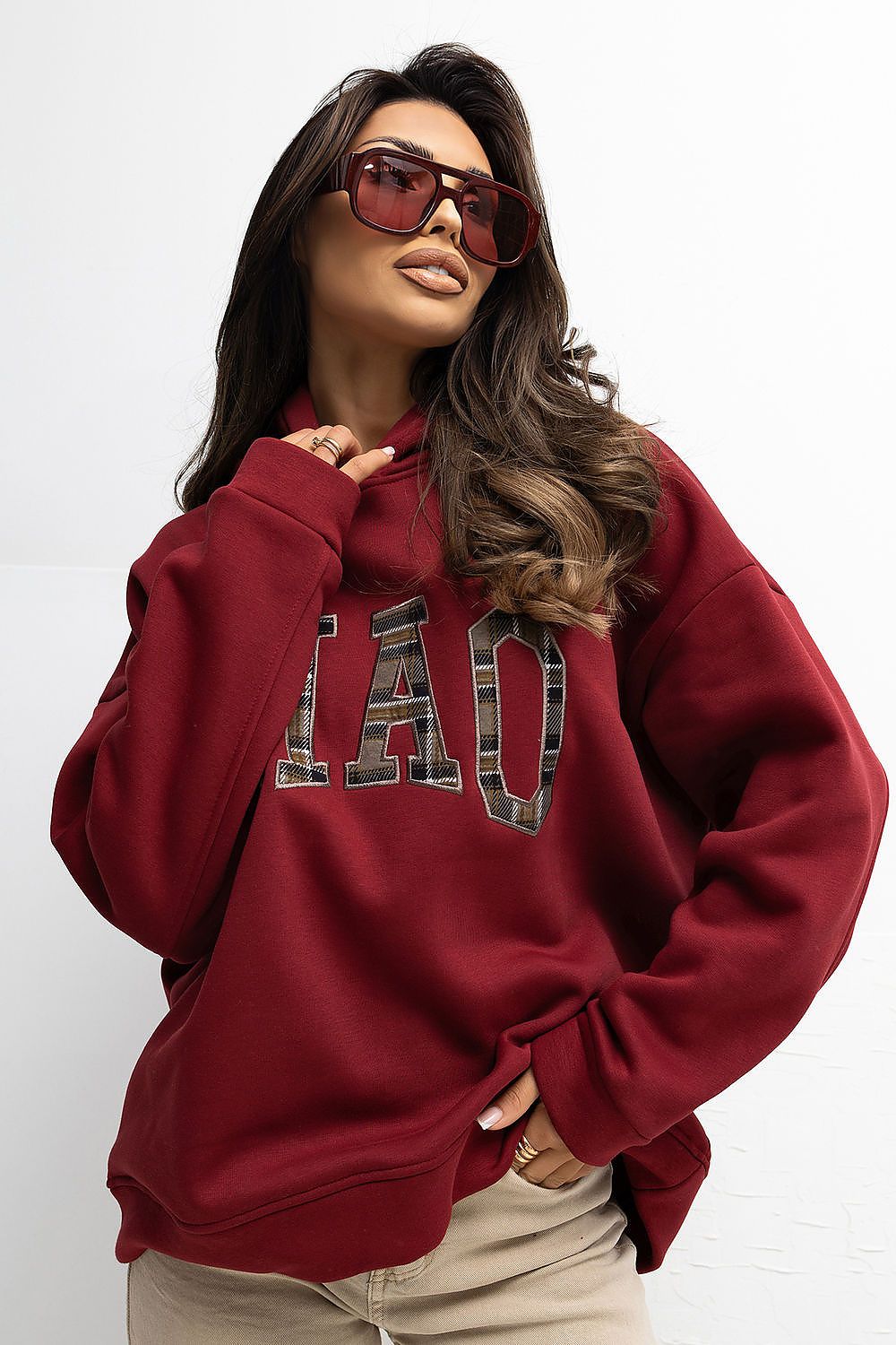 Woman wearing a red sweatshirt with camouflage text on a white background