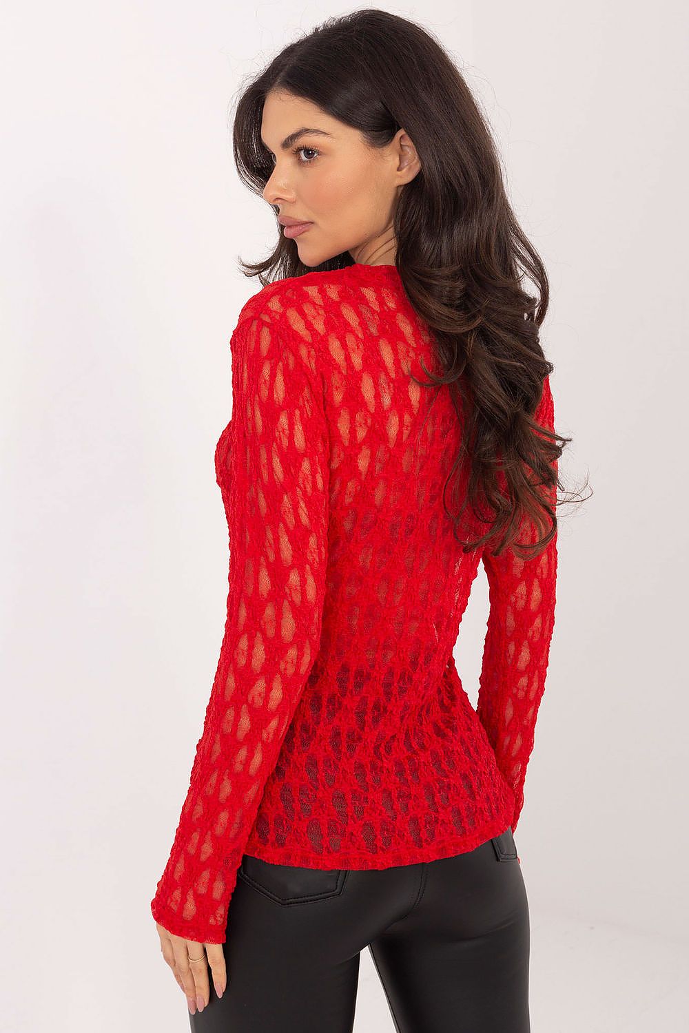 Woman wearing a red lace top against a white background