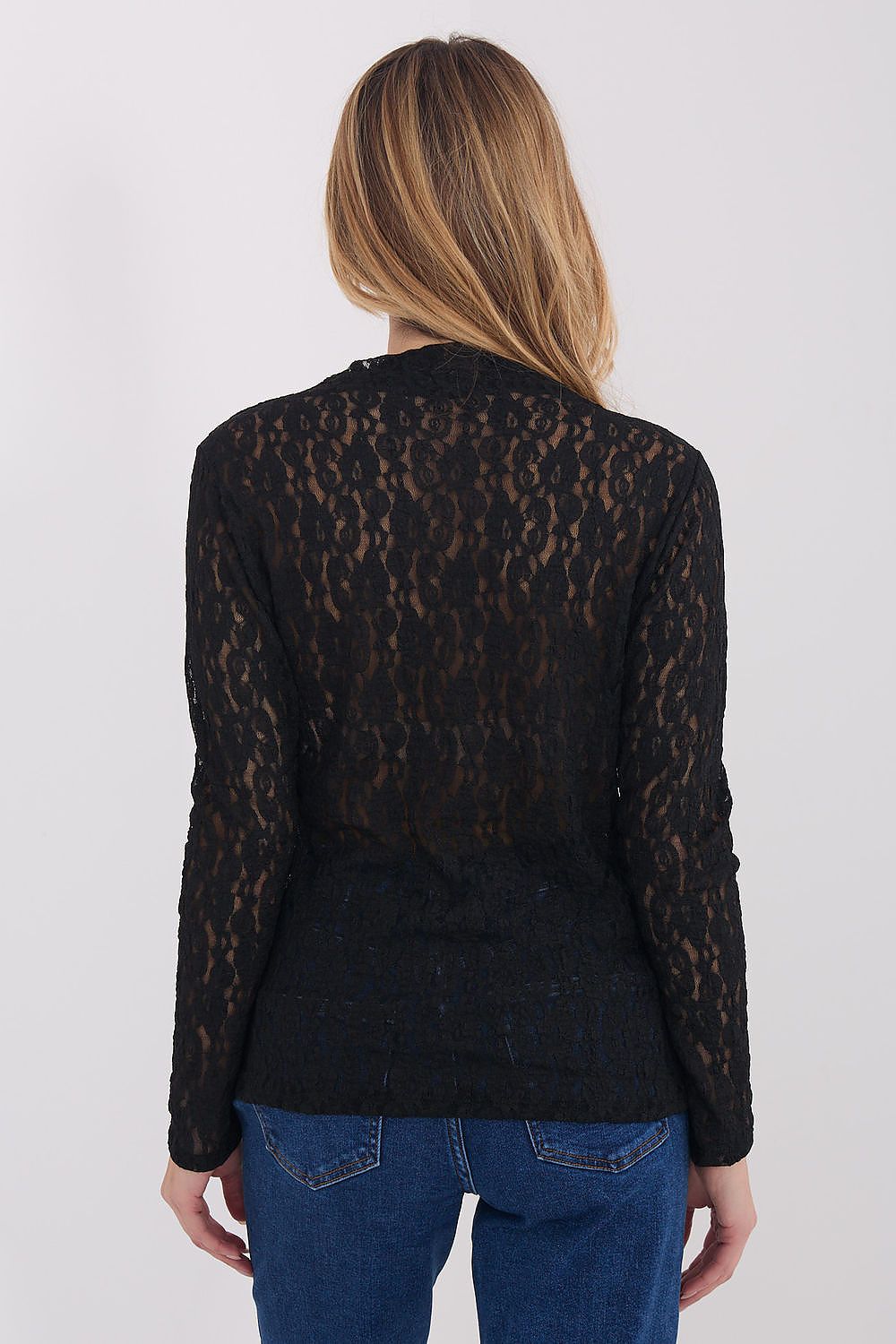 Person wearing a black lace top and blue jeans on a white background