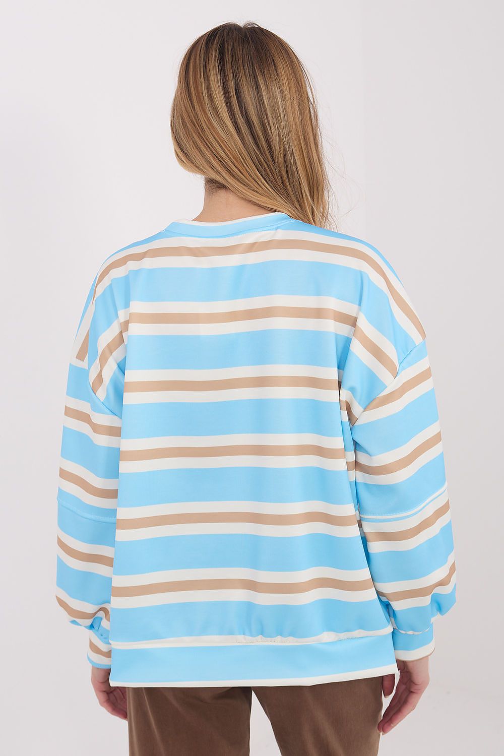 Person wearing a light blue and beige striped sweater on a plain background