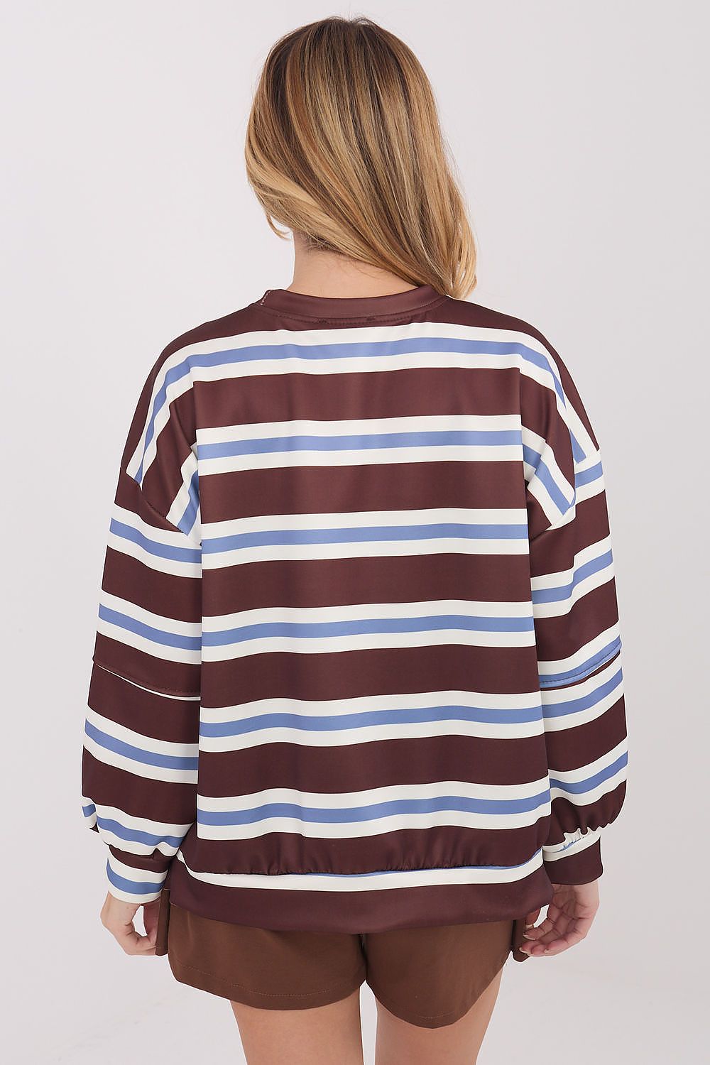 Person wearing a striped sweater with a plain background