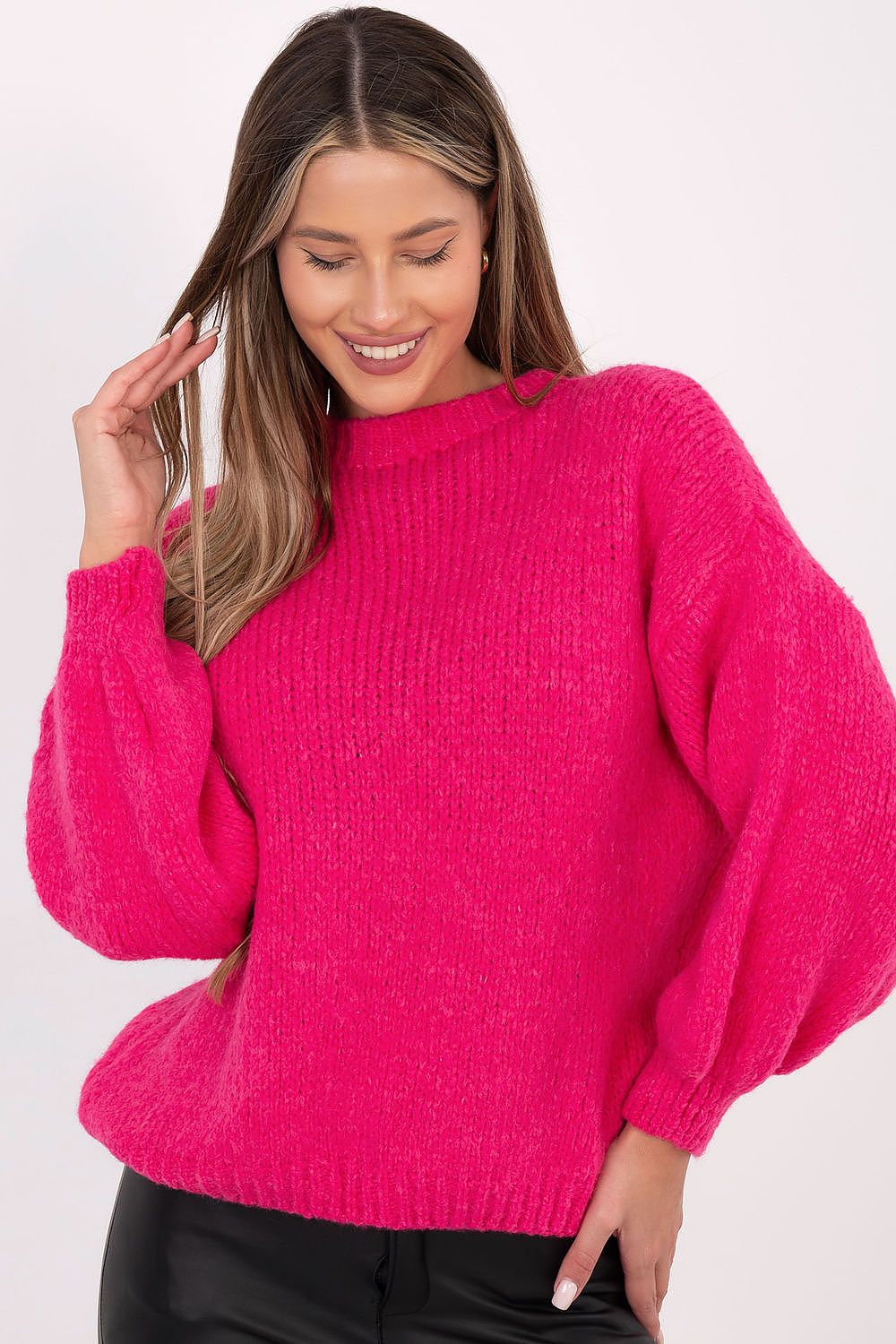 Woman wearing a bright pink sweater on a white background
