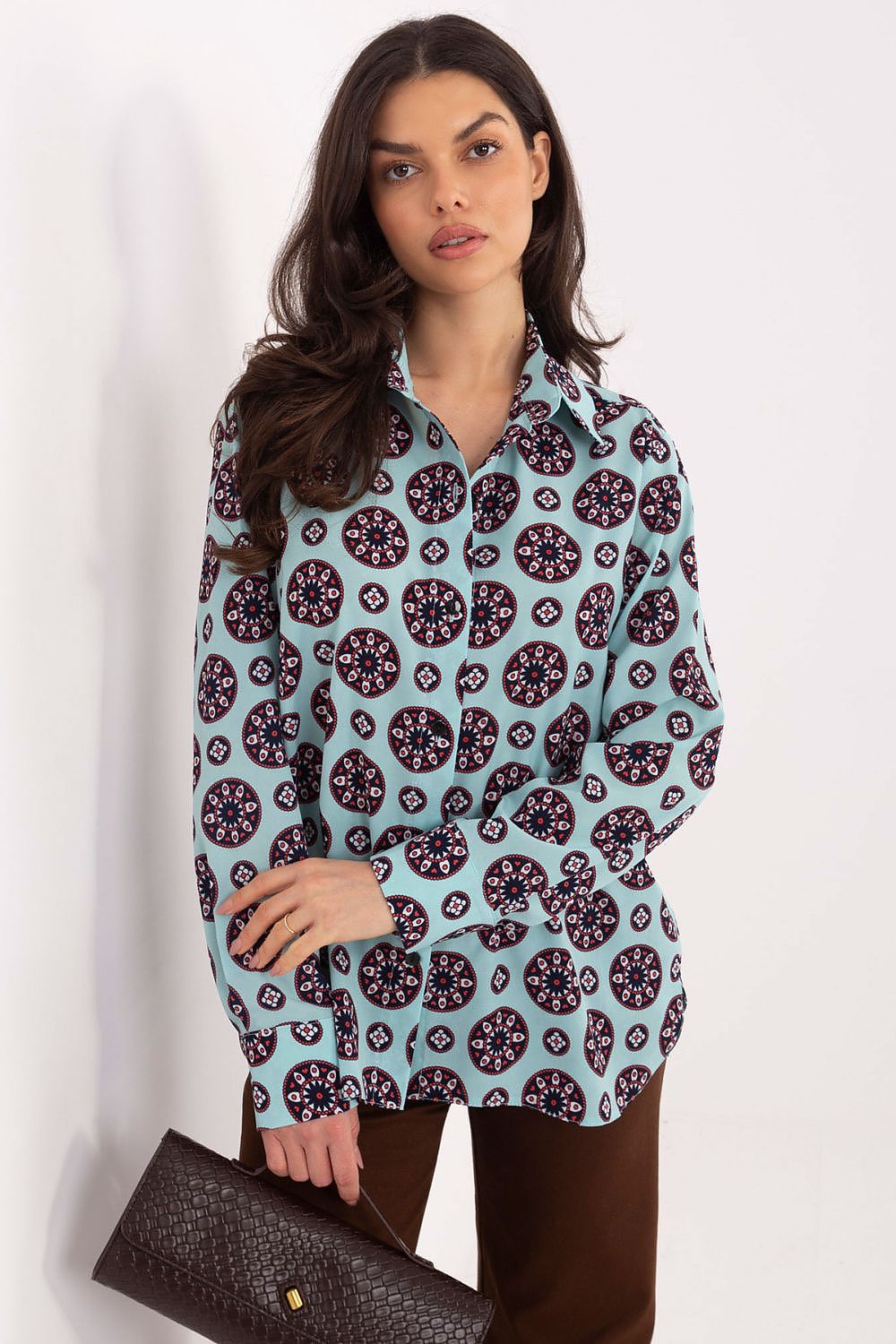 Woman wearing a patterned shirt with a plain background