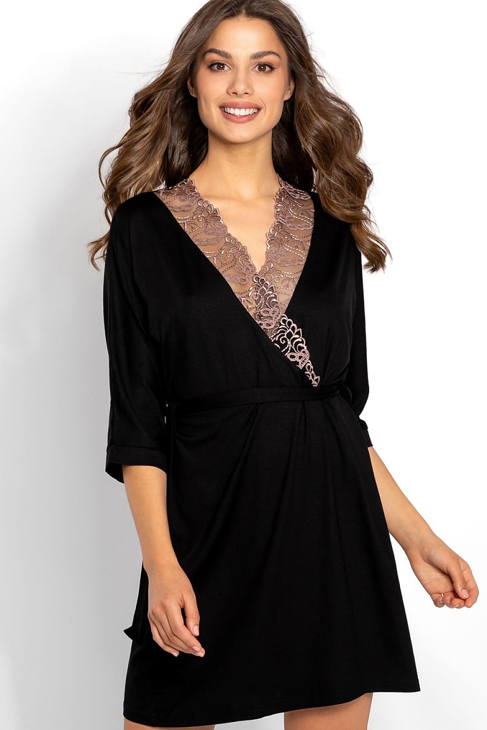 Woman wearing a black dress with lace detailing on a white background