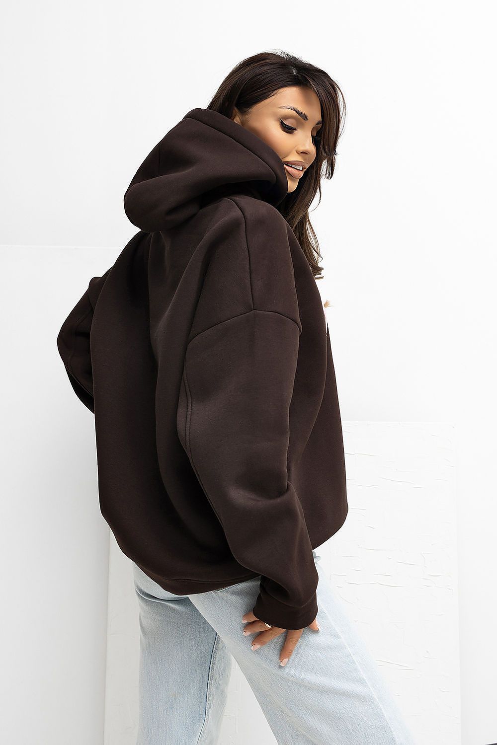 Person wearing a brown hoodie on a white background