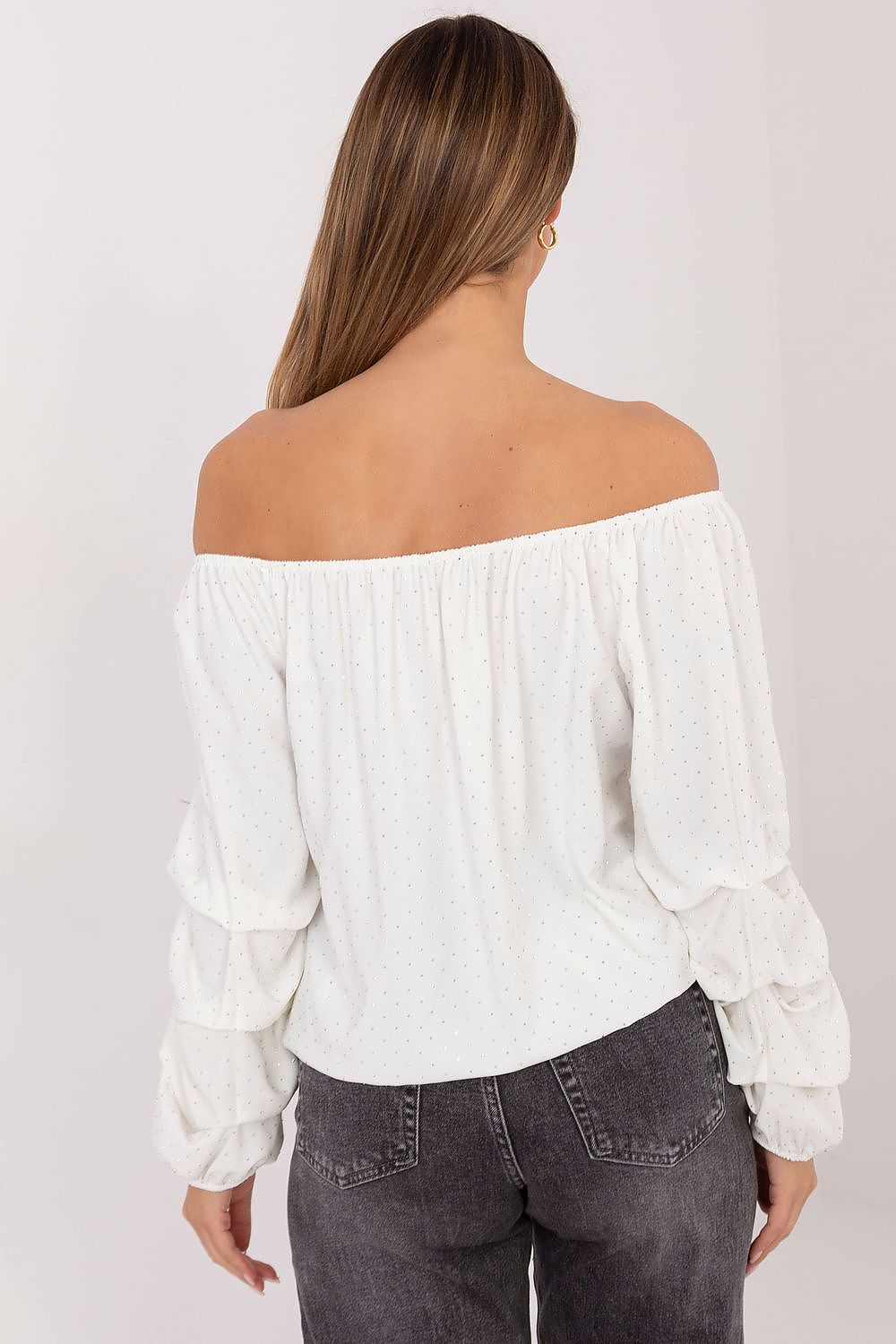 Side angle of beige blouse highlighting neckline and elegant sleeve design