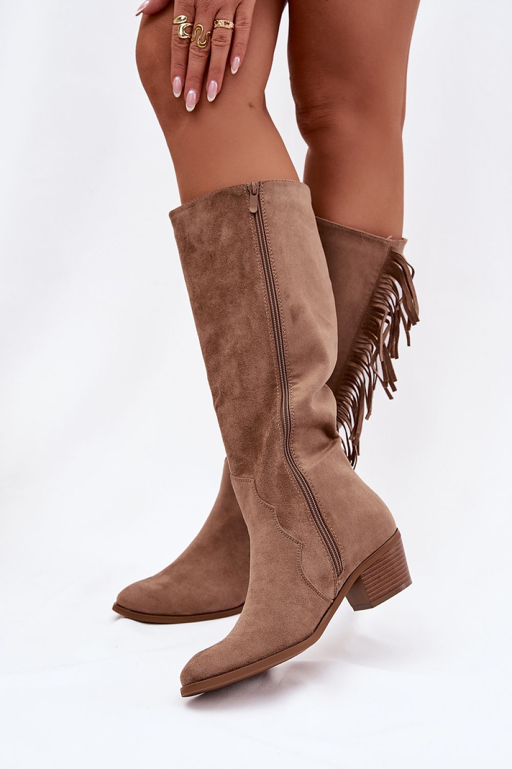 Brown suede knee-high boots with fringe details on a white background