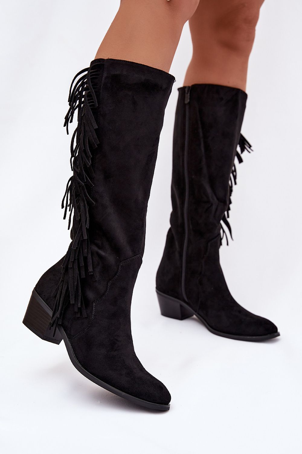 Black fringed knee-high boots on a white background