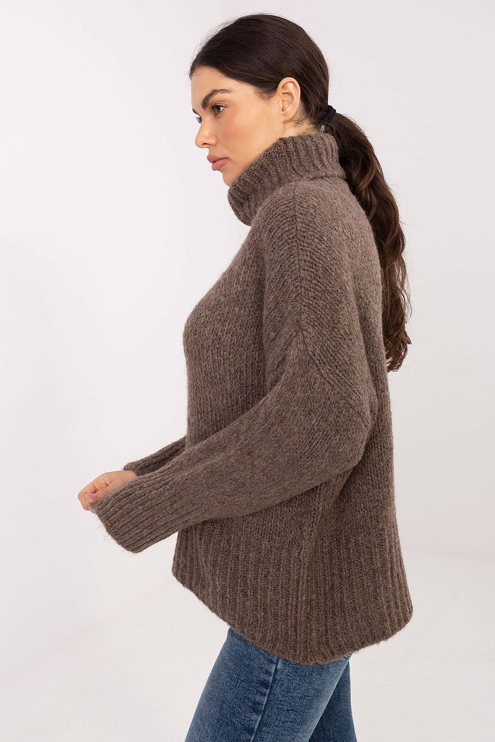 Woman wearing a brown knitted sweater on a white background