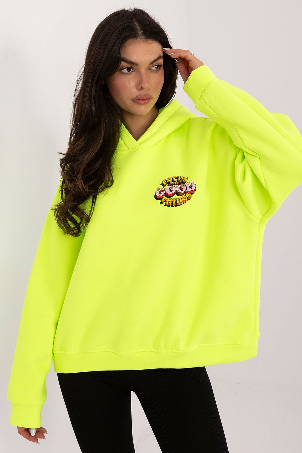 Person wearing a bright yellow hoodie with a colorful graphic on a white background
