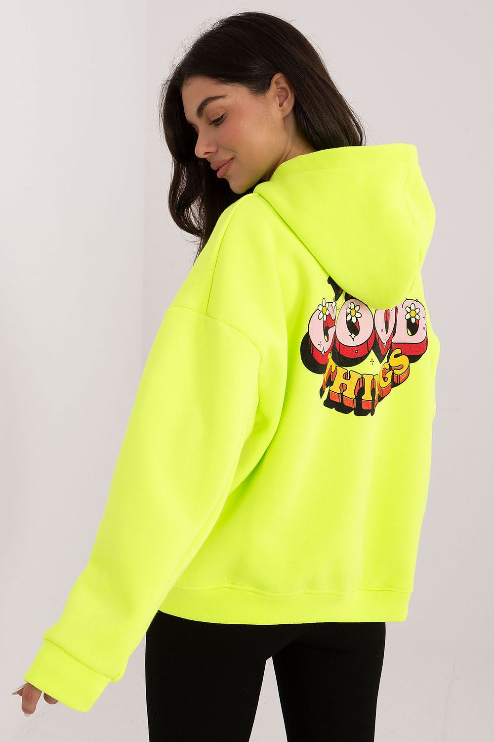 Person wearing a bright yellow hoodie with colorful text design on a plain background