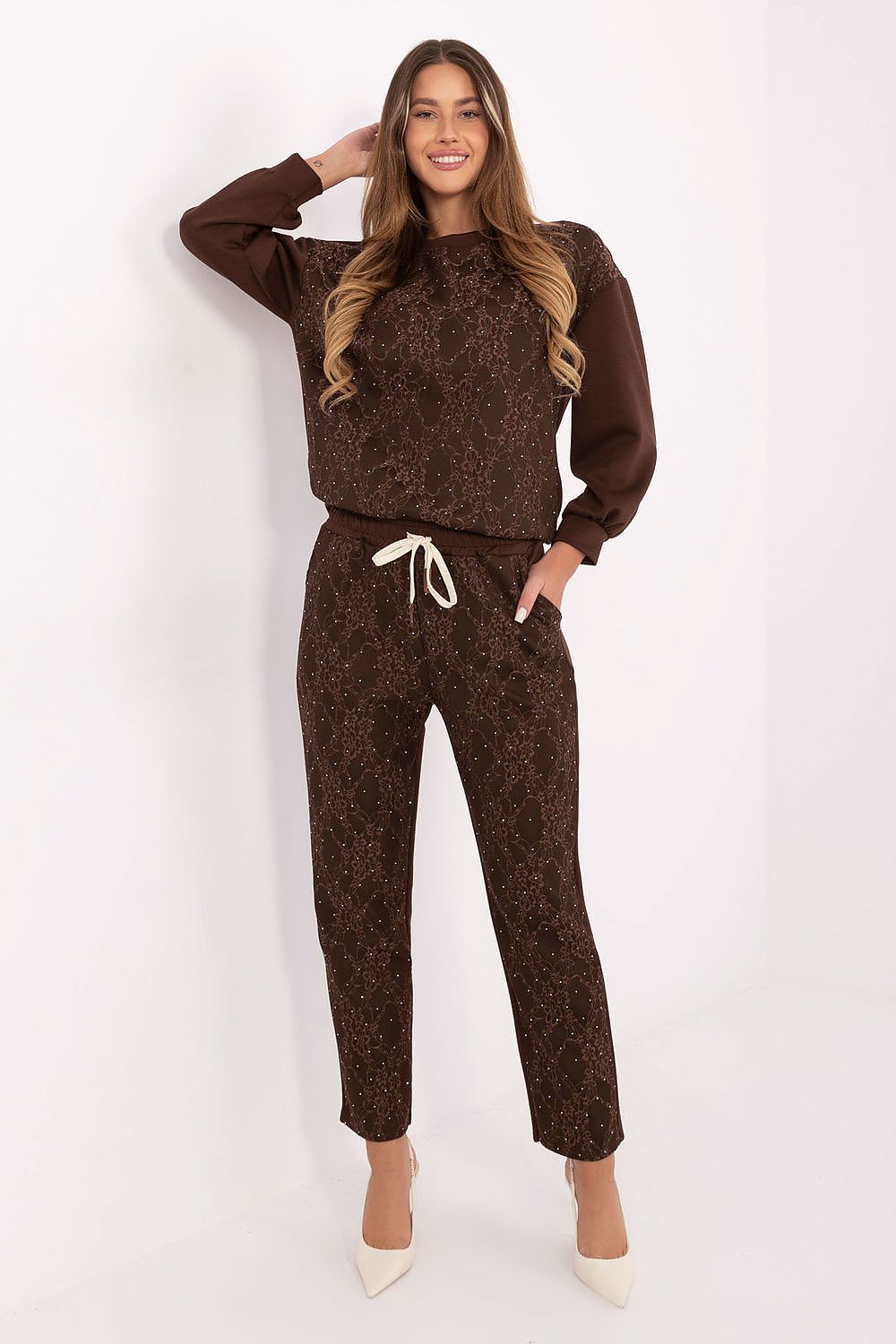 Detailed close-up of brown tracksuit lace and jet applications