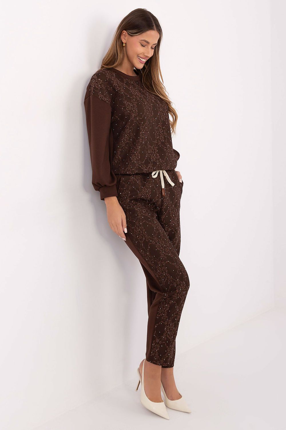 Detailed close-up of brown tracksuit lace and jet applications, side view