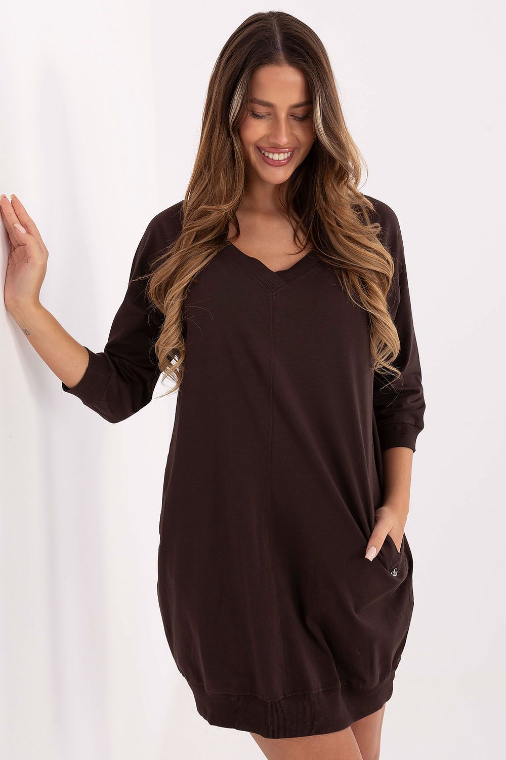 Woman wearing a brown dress against a white background