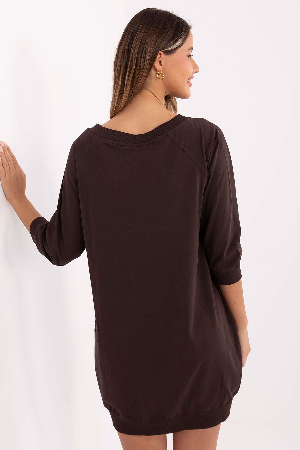 Woman wearing a brown dress against a white background