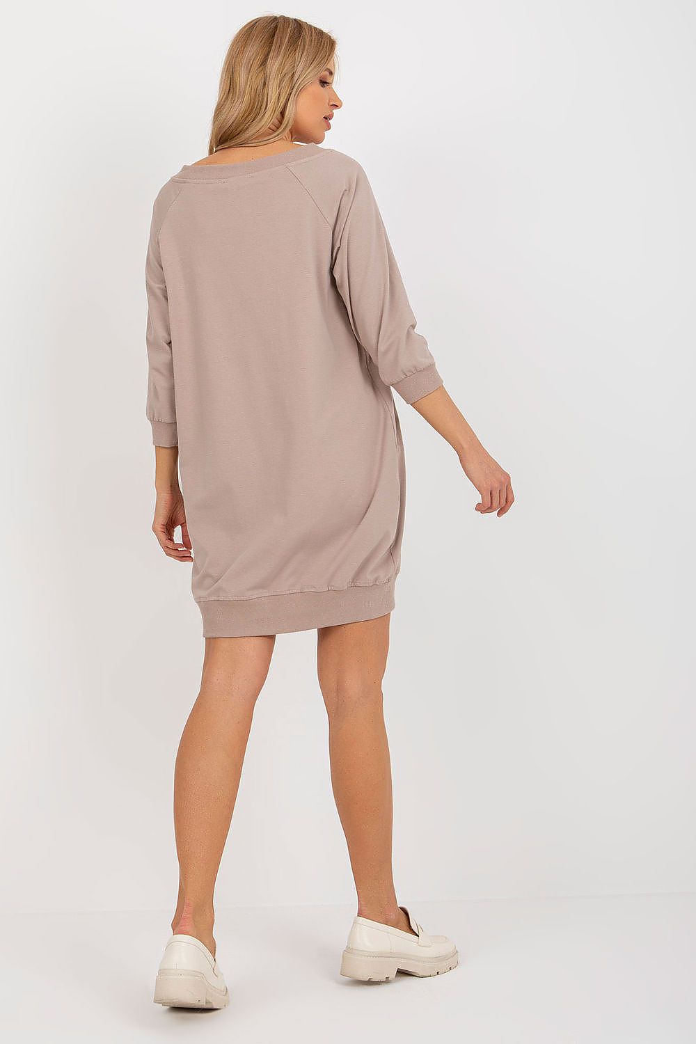 Woman wearing a beige dress on a white background