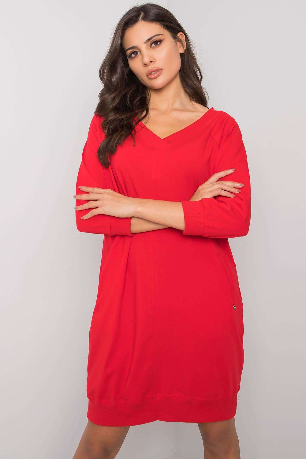Woman wearing a red dress against a plain background