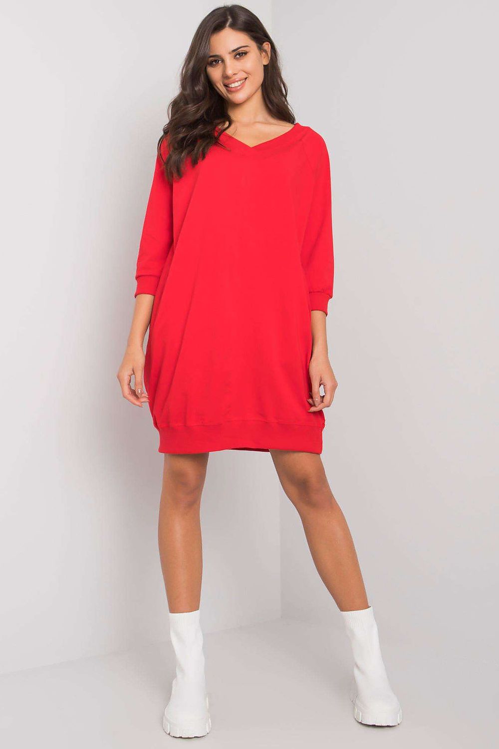 Woman wearing a red dress against a plain background
