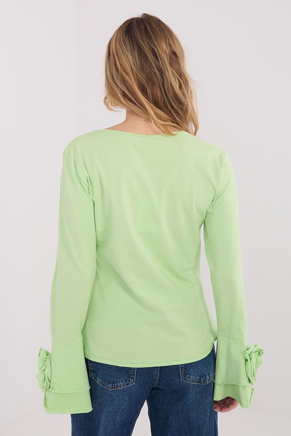  longsleeve blouse with flared sleeves and decorative flowers.
