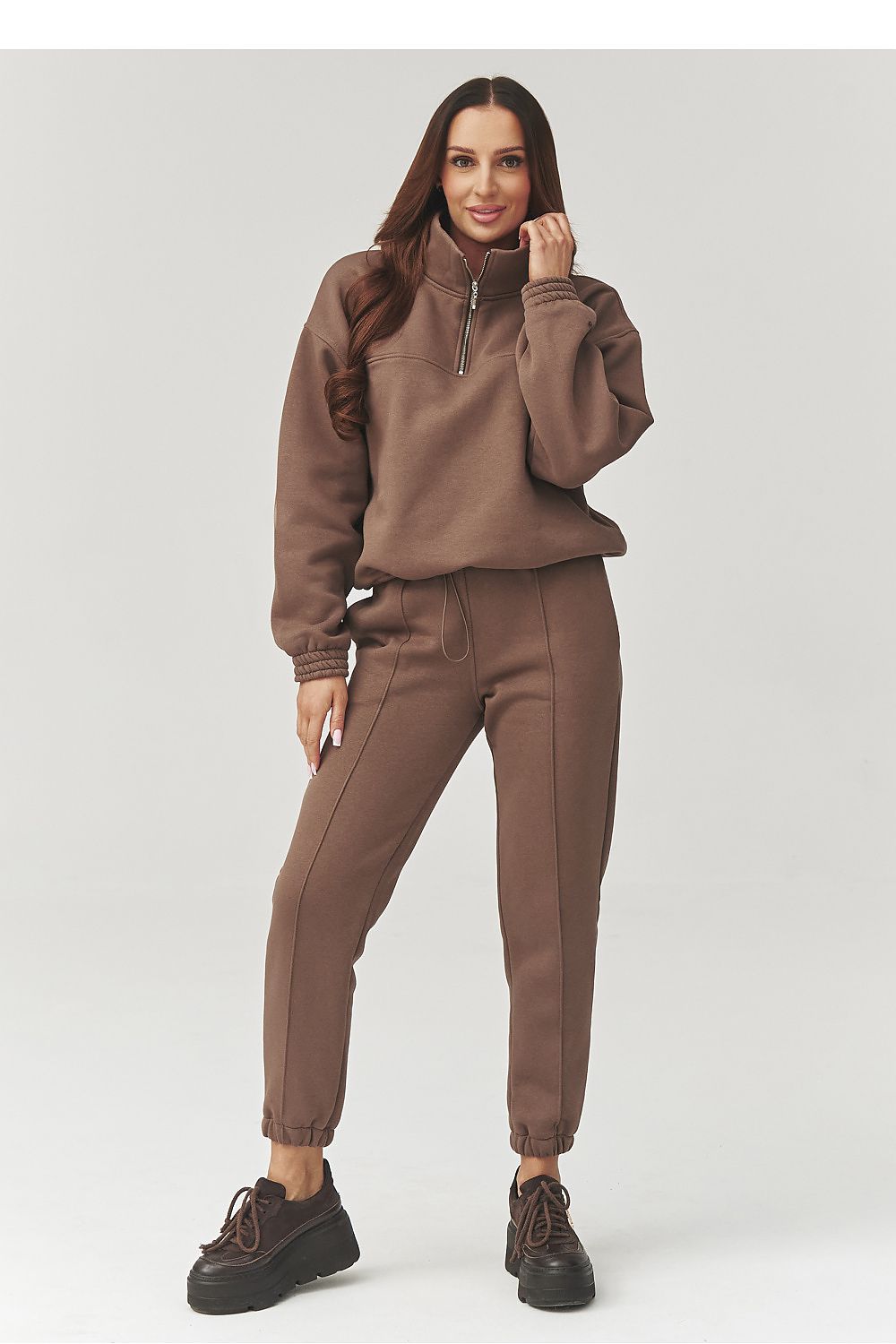 Woman wearing a brown tracksuit on a white background
