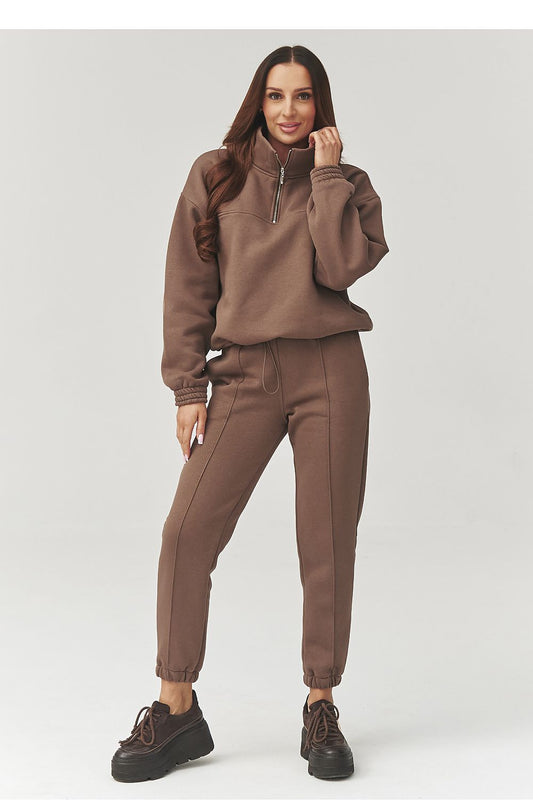 Woman wearing a brown tracksuit on a white background