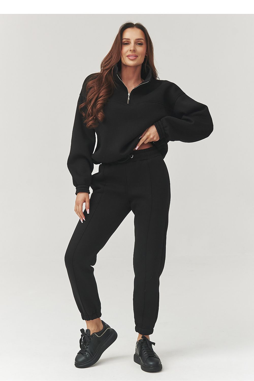 Woman wearing a black tracksuit on a white background
