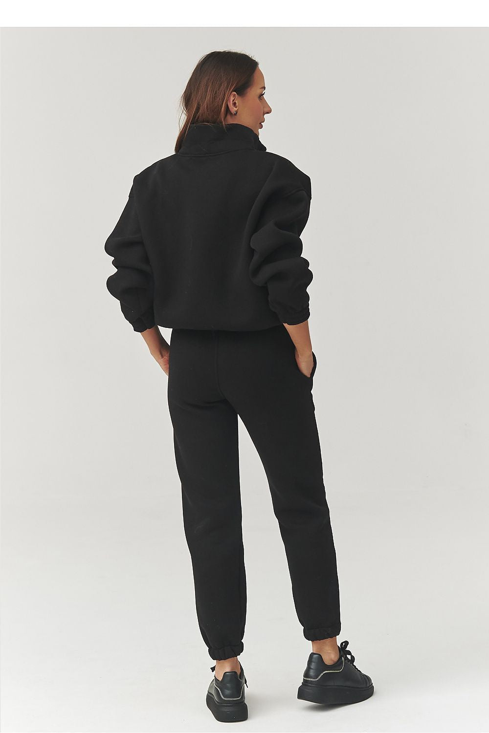 Person wearing a black outfit on a white background