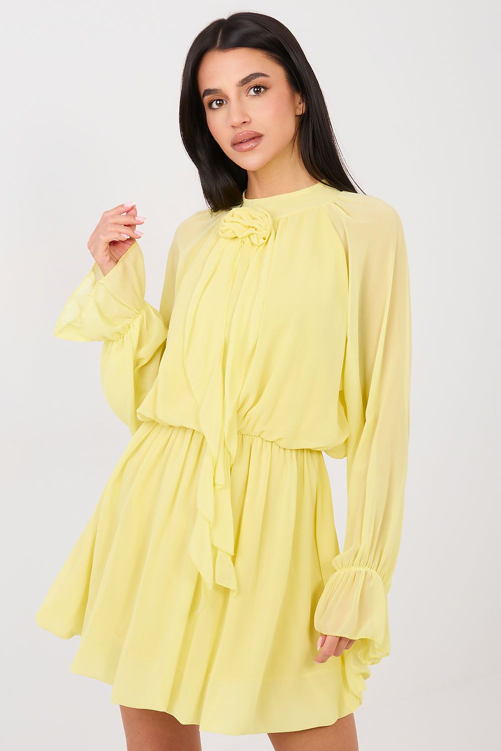 Woman wearing a yellow dress with long sleeves on a white background