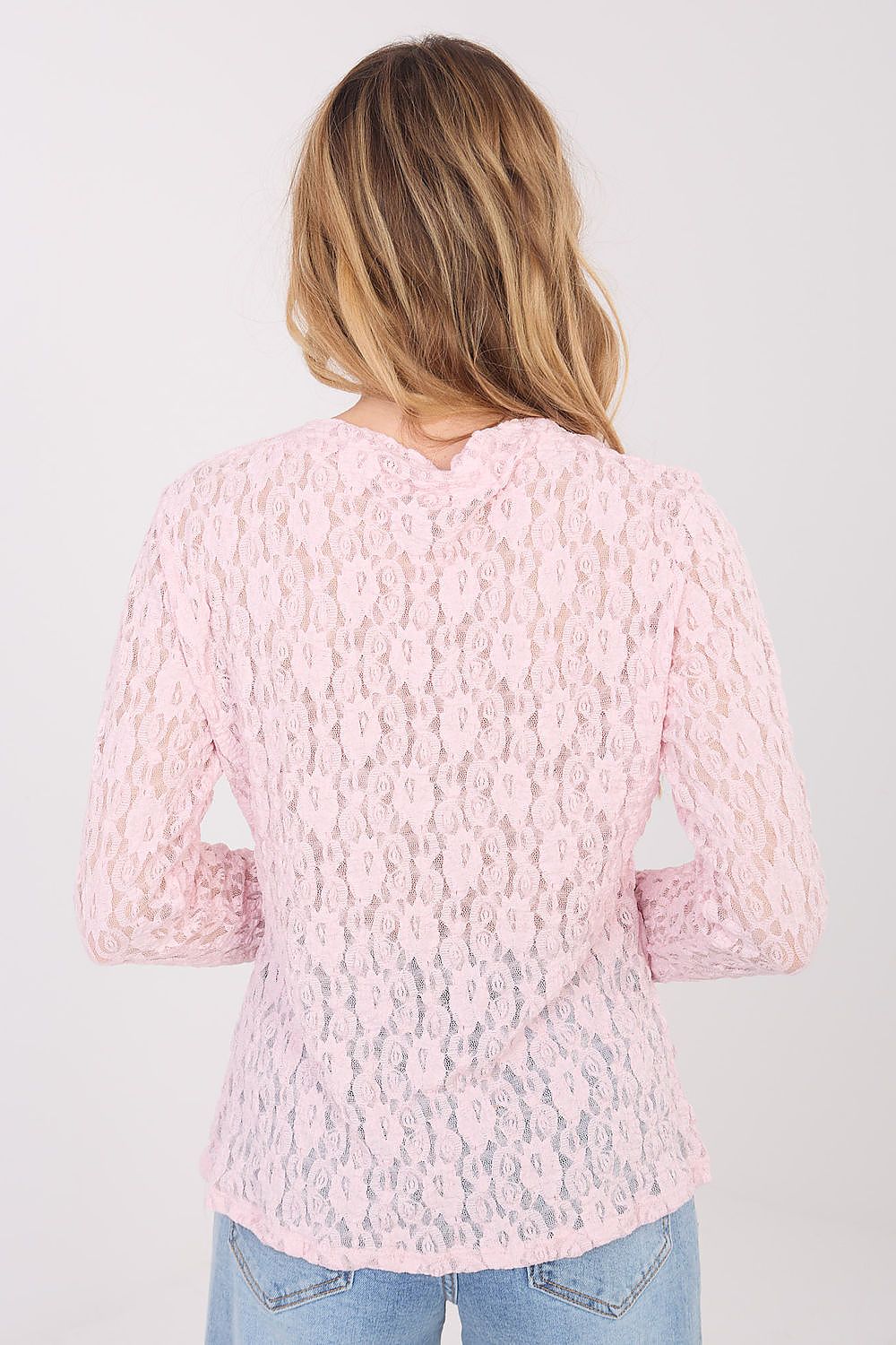 Person wearing a pink textured sweater on a white background