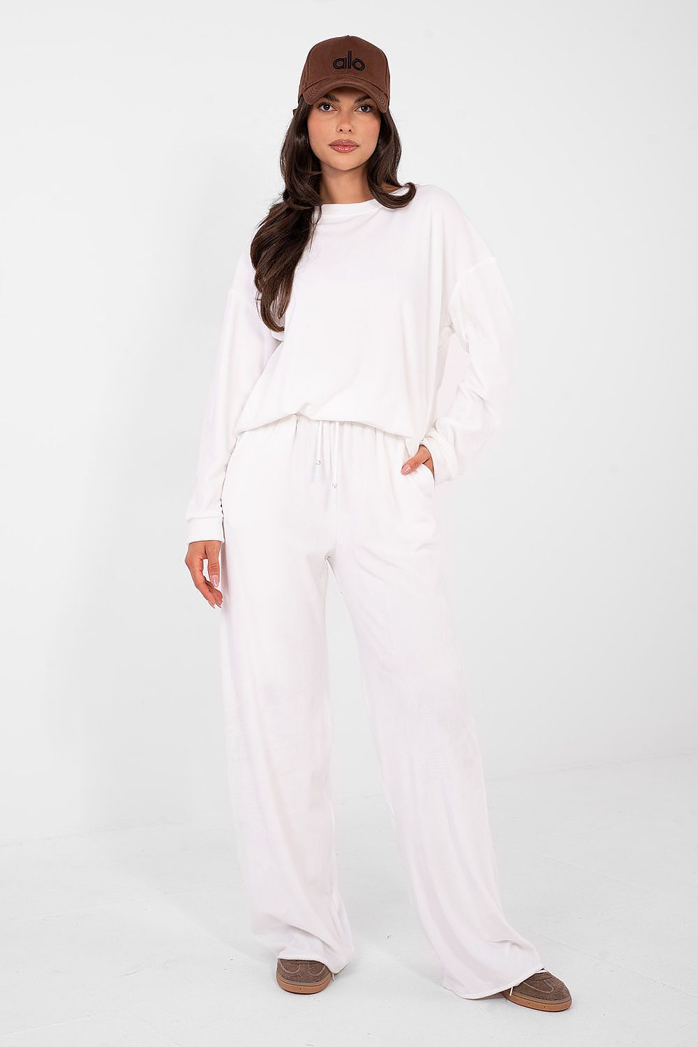 Woman wearing a white outfit with a brown cap on a white background