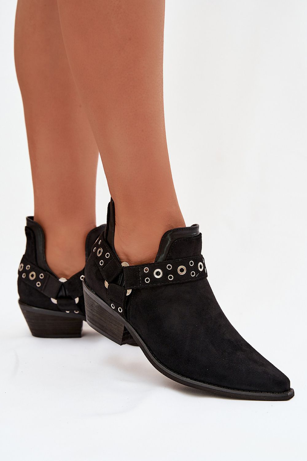 Black suede ankle boots with embellishments on a white background