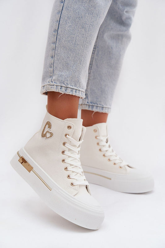 White high-top sneakers with gold accents worn with light blue jeans on a white background