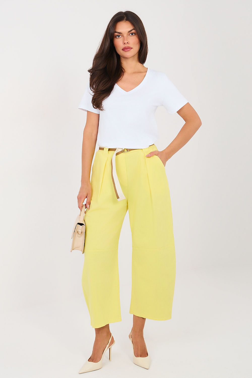 Woman wearing a white top and yellow pants on a white background