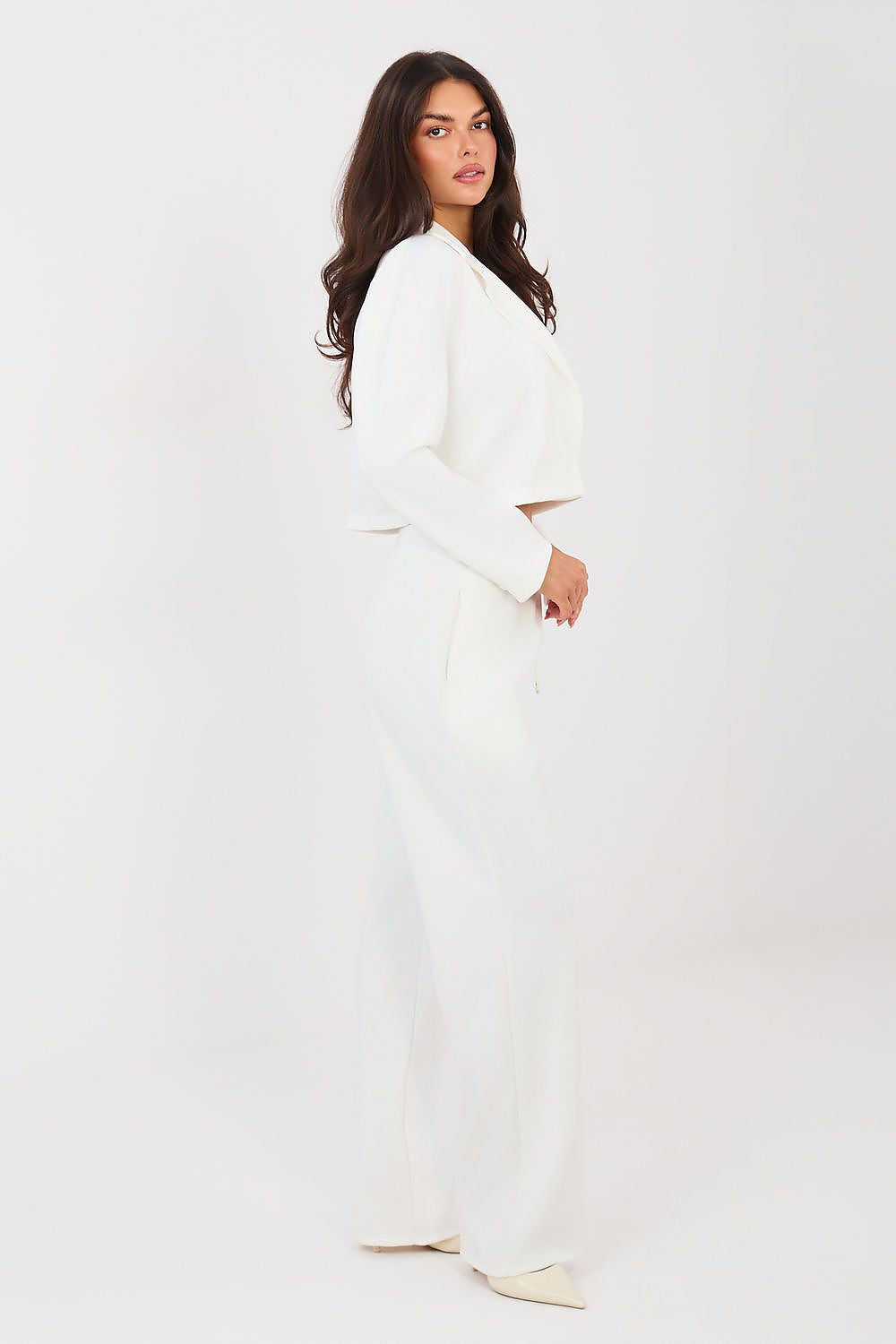 Woman wearing a white dress against a white background