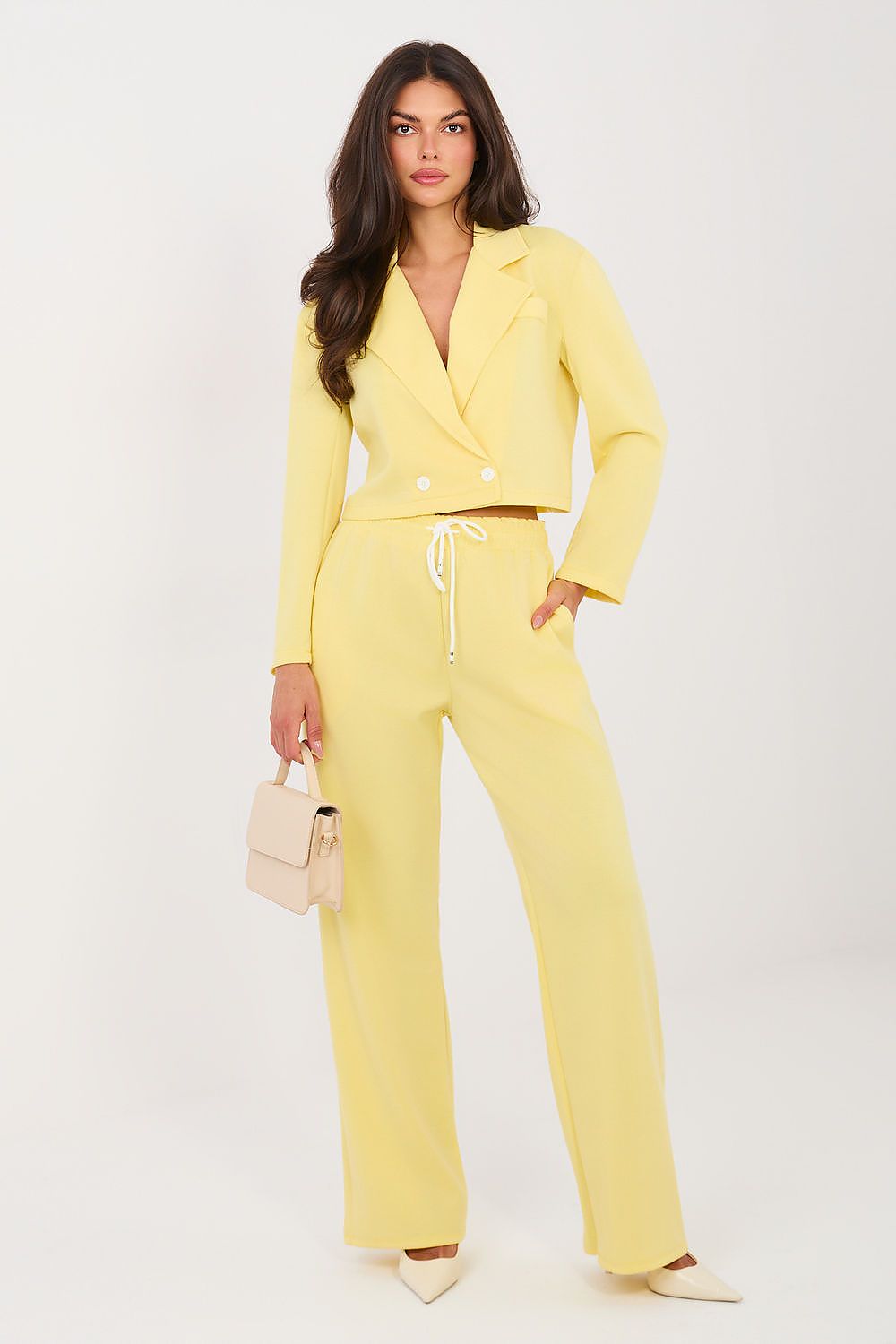 Woman wearing a yellow suit with a white background