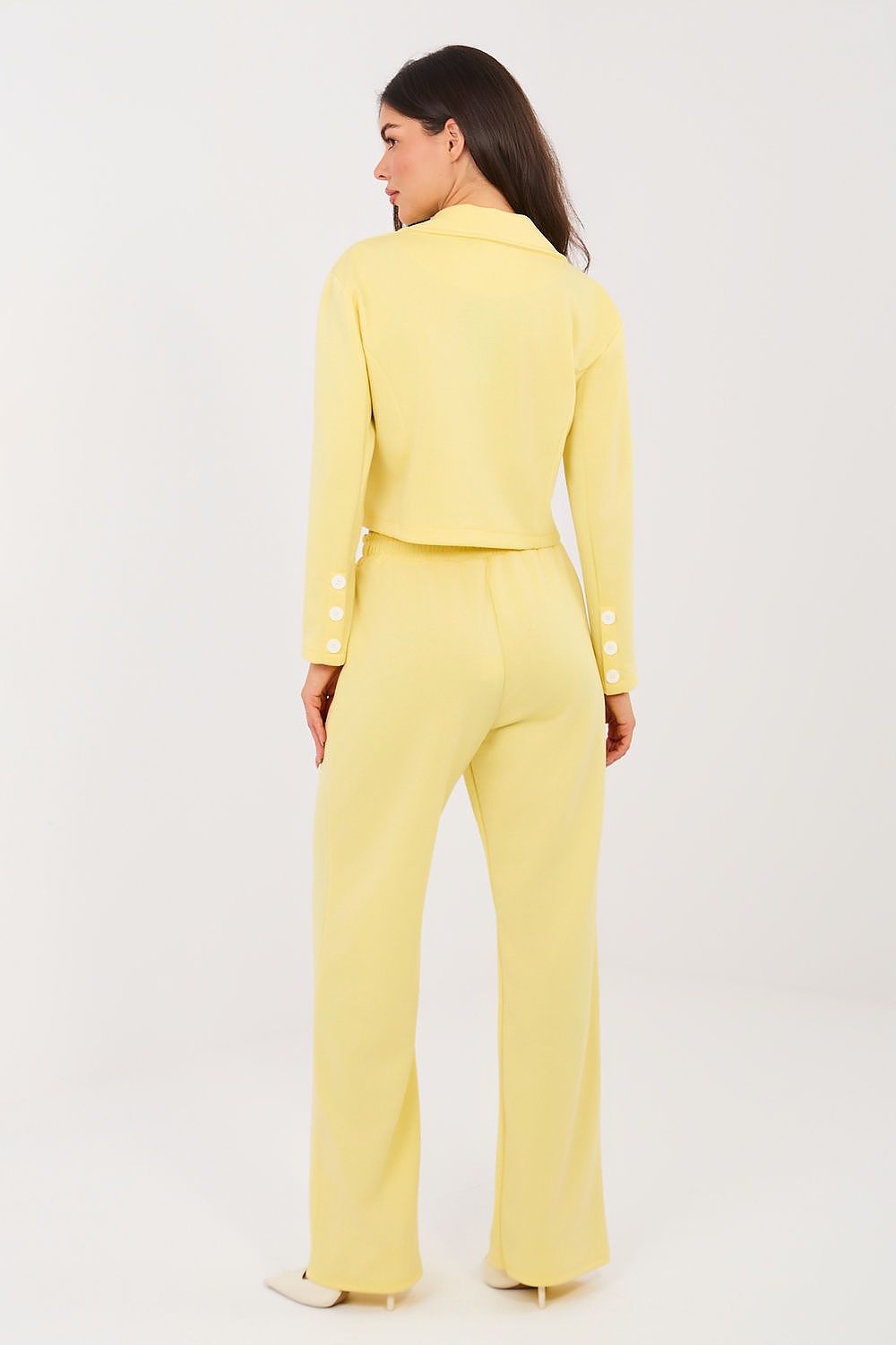 Woman wearing a yellow suit on a white background