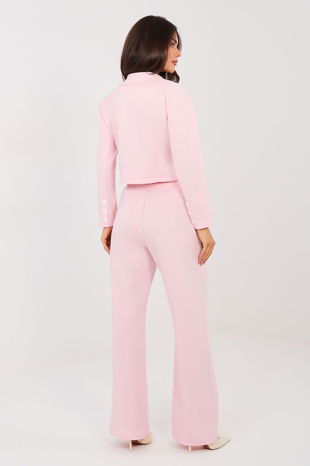 Woman wearing a pink suit on a white background