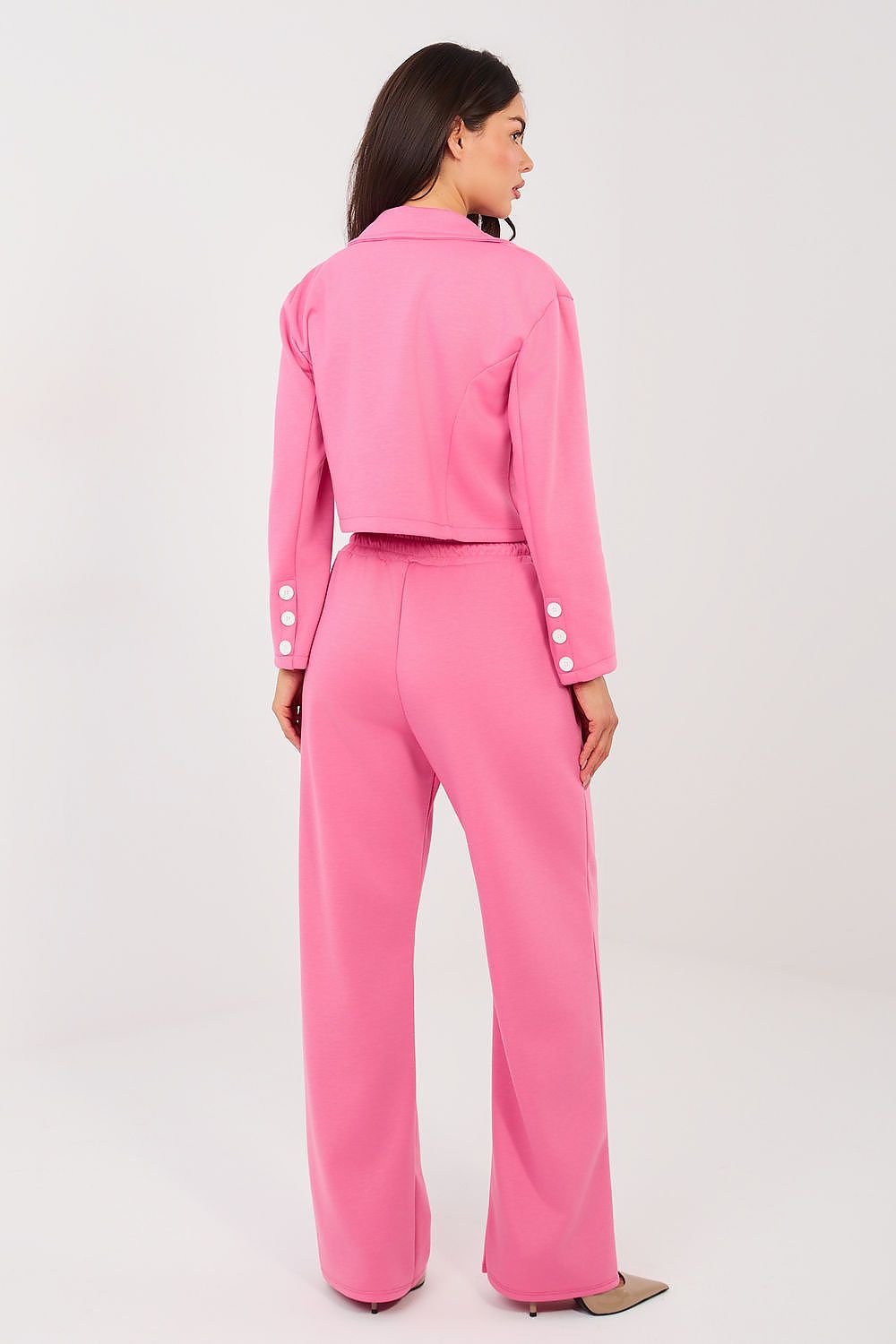 Woman wearing a pink suit on a white background